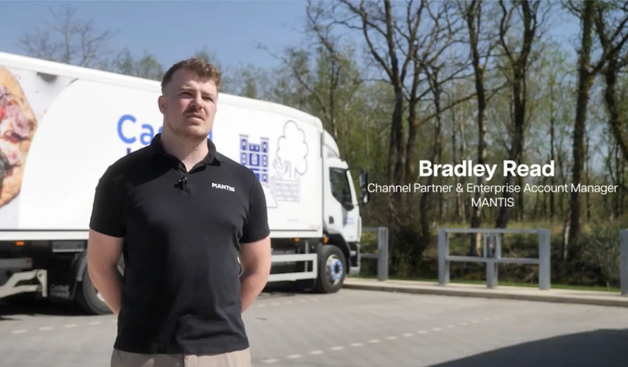 Still from the Castell Howell Foods video case study, with a delivery vehicle behind the speaker